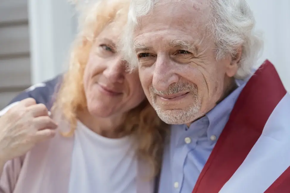 An elderly couple meeting together and hugging.